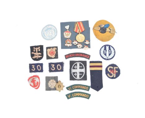 A good collection of assorted WWII Second World War and related cloth uniform cap badges and other items - includes a pair of