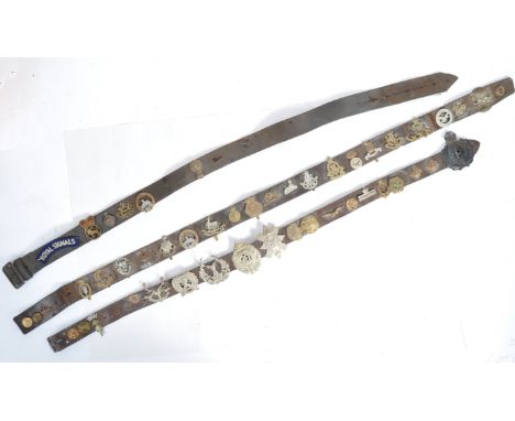 A collection of x3 WWII Second World War British Army leather uniform belts, each with a quantity of original regiment cap ba