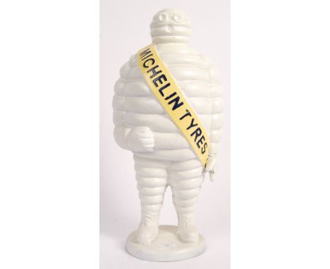 A vintage style 20th century large cast iron advertising figure of Bibendum ( the Michelin Tyres Man ) with yellow sash and h