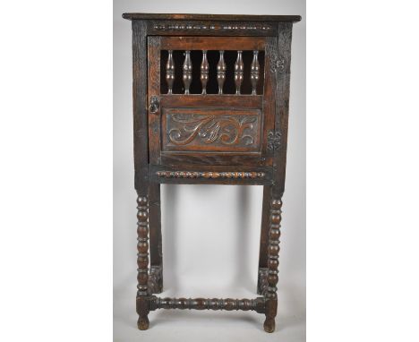 A Carved Oak Two Shelf Bread Cabinet with Panelled and Spindled Door on Bobbin Supports and Stretcher, 16.5cm wide 