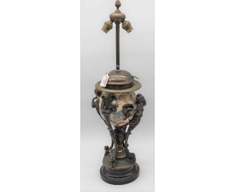 An early 20th century Continental spelter and porcelain twin table lamp, in the classical style, with four figural monopodia 