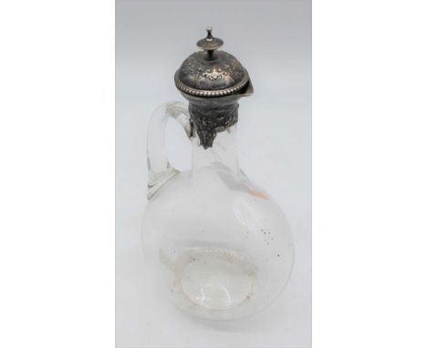 A Victorian carafe, having a clear glass body with loop handle, the silver mount with cork stopper and acorn finial, relief d