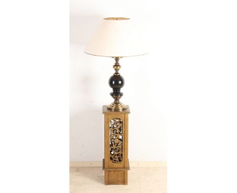 Decorative brass with wooden lamp standing on a Chinese wooden pedestal.&nbsp;20th century.&nbsp;Dimensions: H 150 cm.&nbsp;I