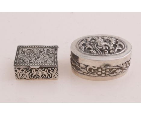 Two silver boxes, 925/000, an oval model with a hinged lid and a decoration with flowers, 4.5x3.5x2cm, and a rectangular box 
