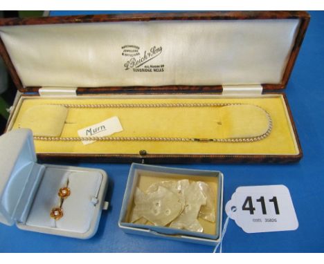 A pearl necklace, earrings and some counters