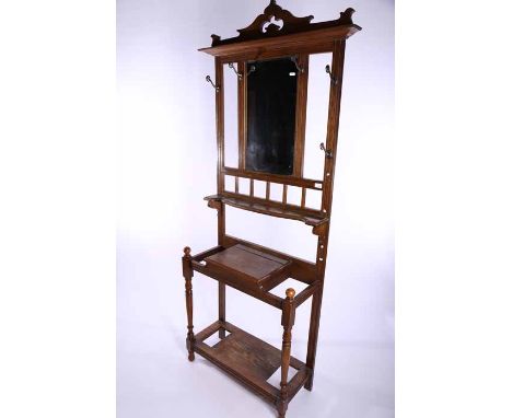 LATE VICTORIAN OAK HALLSTAND
with central bevelled mirror, open shelf, hinged glove box and two stick compartments, on turned