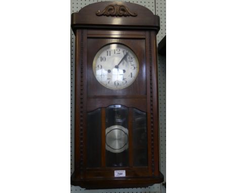 An early 20th Century oak cased wall clock with glazed door