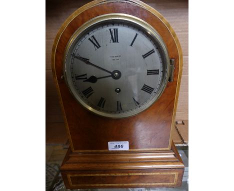 An early 20th Century burr walnut cased mantel clockWith circular silvered dial with Roman numerals, marked Preston's Ltd Bol