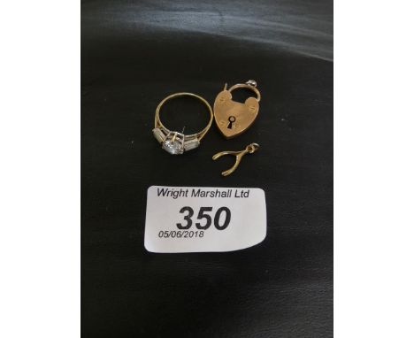 A 9k gold and colourless three stone ring, together with, a precious rose metal heart padlock stamped 9ct, and a wishbone cha