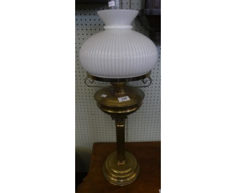 An early 20th Century brass oil lamp with opaque glass shade and Corinthian type column