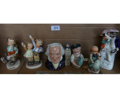 A mixed lot comprising three Goebel figurines, two Royal Doulton character jugs and a Staffordshire figure group (6)