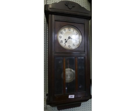 An early 20th Century oak cased wall clock with glazed door