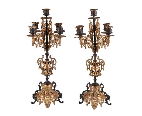  A pair of French gilt and patinated metal five light candelabra,   late 19th century, each with a Vitruvian scroll cast urn 