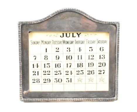 An Edwardian&nbsp; hallmarked silver mounted desk calendar. The calendar having interchangeable month and day sheets. Hallmar