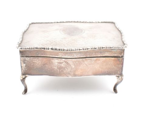 A hallmarked silver lined trinket box. The box on cariole legs to hinged lid having engine turned decoration opening to revea