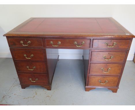 A good quality 19th century desk with a tooled leather top over nine drawers with brass swan neck handles, with replaced brac