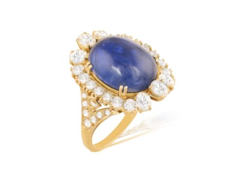 A STAR SAPPHIRE AND DIAMOND RINGSet with a cabochon star sapphire weighing approximately 12cts, framed by oval-shaped and bri