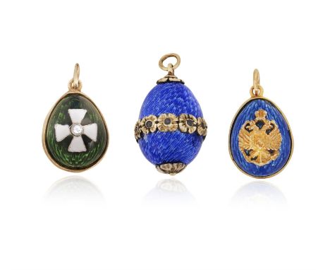 THREE EARLY 20TH CENTURY EASTER EGG PENDANTS The first egg pendant applied with blue guilloché enamel, with a central flower 