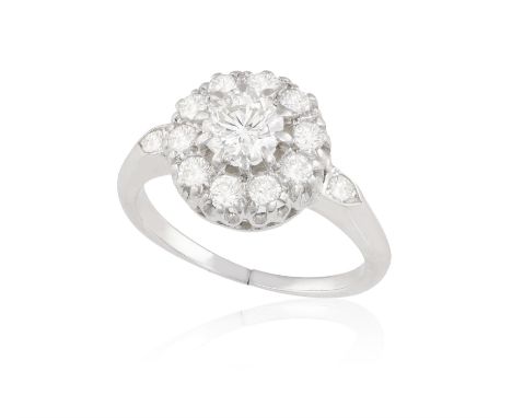 A DIAMOND DRESS RINGOf cluster design, centring a brilliant-cut diamond, to a brilliant-cut diamond surround, shoulders enhan