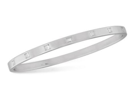 A DIAMOND BANGLE BRACELET Of rigid polished design, set to the front with seven square-shaped diamonds, mounted in palladium,