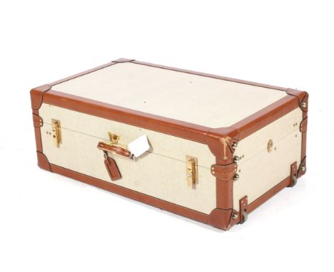 A contemporary Henry's tan leather-bound trunk type suitcase. With fitted interior, leather handles, wheels and brass locks. 