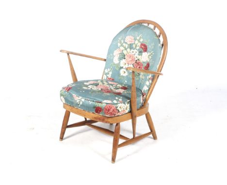 Mid-century Ercol light elm stickback open armchair. Green and gold label to the back of the seat, with sprung seat, on turne