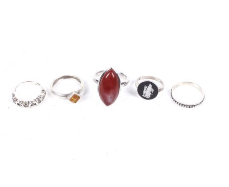 Five gem-set silver and white metal rings. Including a cubic zirconia seven stone wavy ring, size L; a Baltic amber single sq