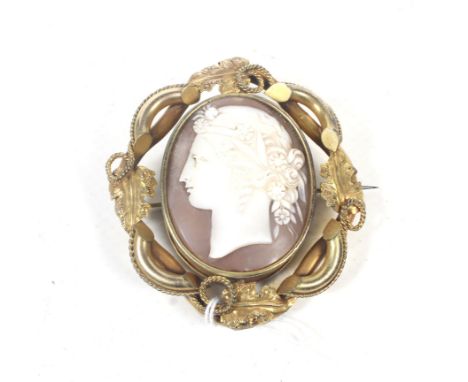 A Victorian gold plated and shell cameo oval locket-back brooch. Depicting a neoclassical interpretation of Flora, rub-over s