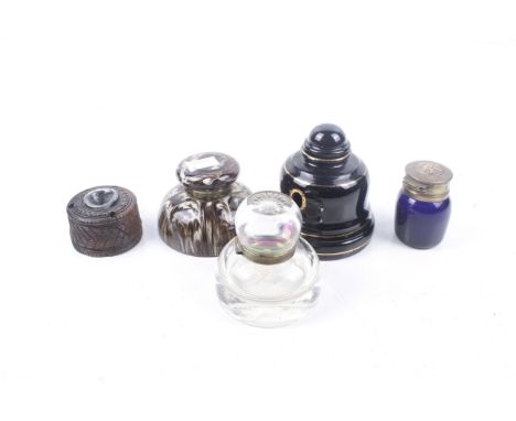 Five 20th century inkwells. Including a 1920s blue glass inkwell, the brass lid decorated with a stork, H6.5cm, a black glaze