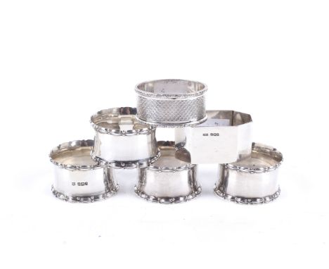 A set of four silver napkin rings and two others. Comprising four with fluted oval and bead borders, Sheffield 1917; together