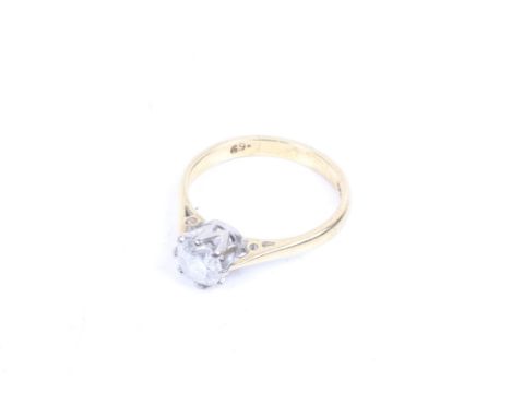 An 18ct gold and diamond solitaire ring. The round brilliant cut stone approx. 0.69cts carats, claw set in white on a yellow 