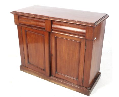 An Edwardian mahogany cupboard. With two drawers over a pair of panelled doors, opening to reveal a single shelf, on a plinth