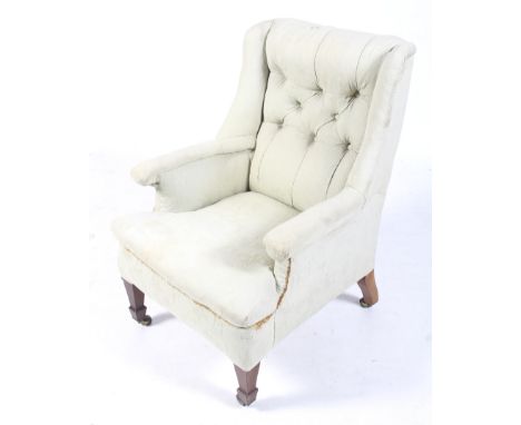 An early 20th century wingback armchair. Upholstered in light green fabric with a button back, raised on tapered supports, on