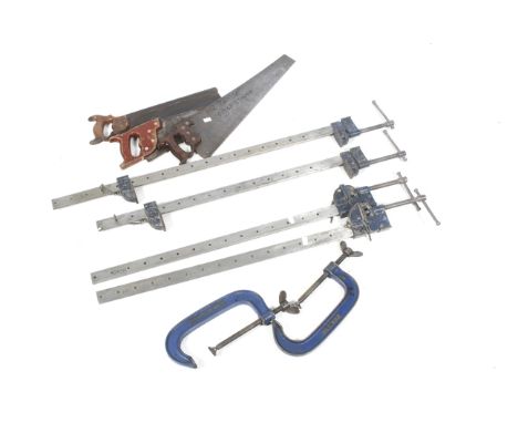 A collection of tools. Including four sash clamps, two G clamps and three saws. 