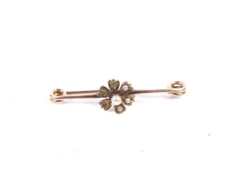 A late Victorian gold and half-pearl pin brooch. Centred with a six-petal flower-head stamped verso '15ct', 2.2g gross, L4cm