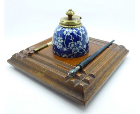 An oak ink stand with blue and white inkwell