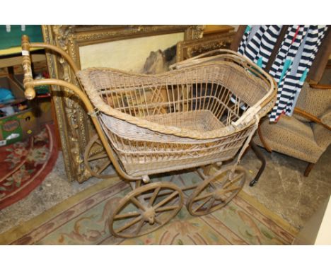 A VINTAGE WICKER PRAM WITH WOODEN WHEELS