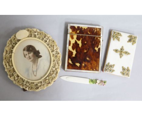 A carved ivory circular frame, an ivory page marker, a French aide memoir and a tortoiseshell card case