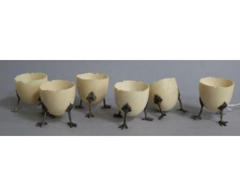 A set of six ivory egg cups, modelled as half egg shells of three chick leg supports, (one a.f.), height 47mm.