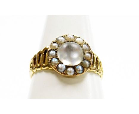 A Victorian moonstone dress ring, the circular central panel set with a large moonstone surrounded by seed pearls, on a four 