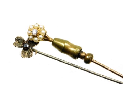 Two stick pins, a diamond and seed pearl cluster pin, yellow metal stamped 15ct, and a silver pin in the form of a three leaf