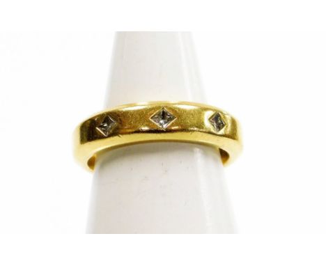 An 18ct gold wedding band, set with three tiny diamonds in a star setting, with applied adjuster clips to inner band, ring si