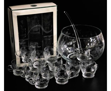 A cut glass punch set, comprising punch bowl, ladle, and twelve cups, decorated with leaves and grapes, etc, and a set of six