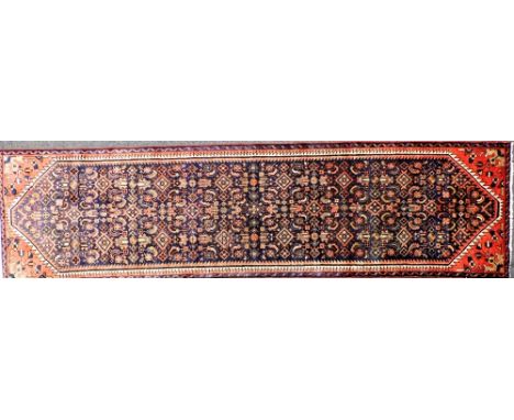 A Persian blue ground runner, decorated with an all over stylised floral decoration, within dog tooth borders, 281cm x 76cm. 