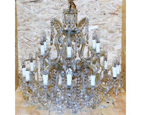 A cut glass chandelier, with rows of beads and faceted lustre drops, formed as two tiers of six and twelve arms, 79cm wide.  