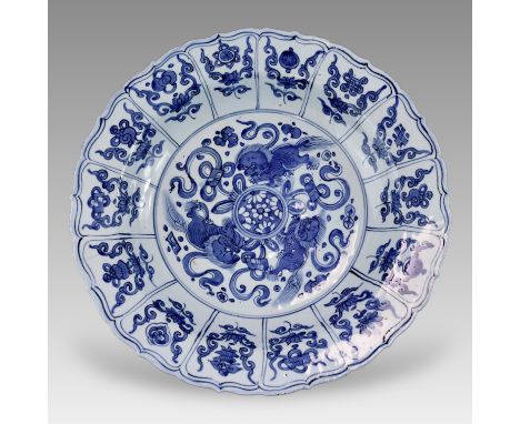 A blue and white charger, with a central medallion of three Buddhist lions, with radiating panels of lotus and Buddhist emble