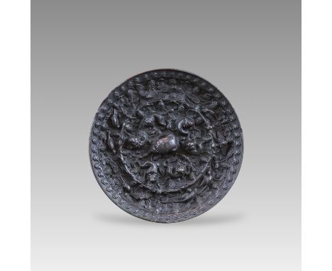 of circular shape, the recessed centre well cast with a lion knop encircled by six smaller recumbent mythical beasts and grap