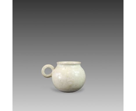the globular body set with a circular ring handle, the almost white ware covered with a clear glaze, A similar cup from a Ger