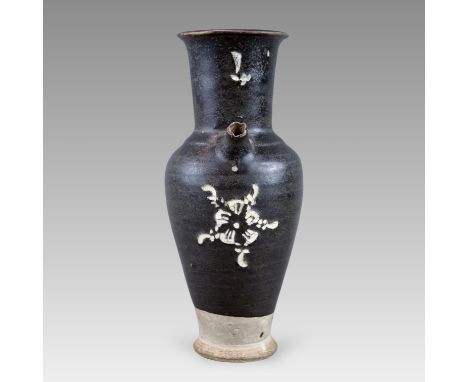 the slender baluster body rising from a splayed foot to the tall neck and everted rim,  set with a loop handle opposite the s