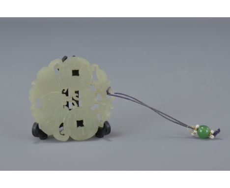 A Chinese Jade carving of coins and butterfly on plastic display stand, Jade carving 5.5cm diameter